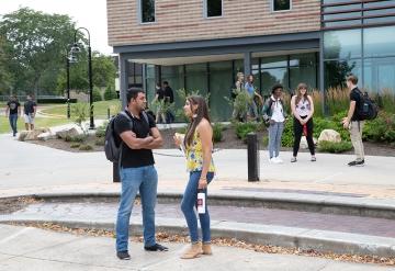 Students in groups and walking at the end of the quad